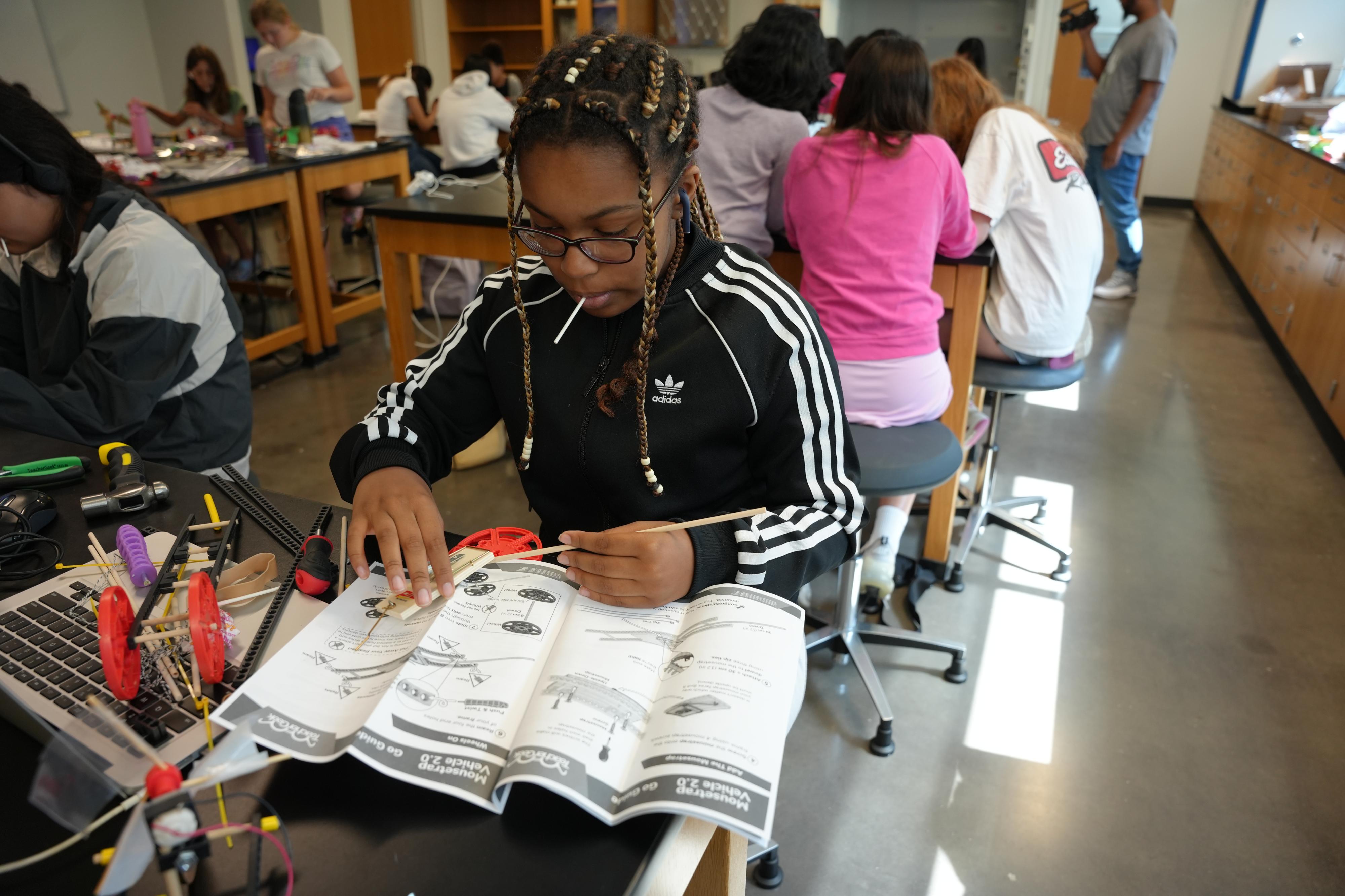 Student reading directions while eating a candy.